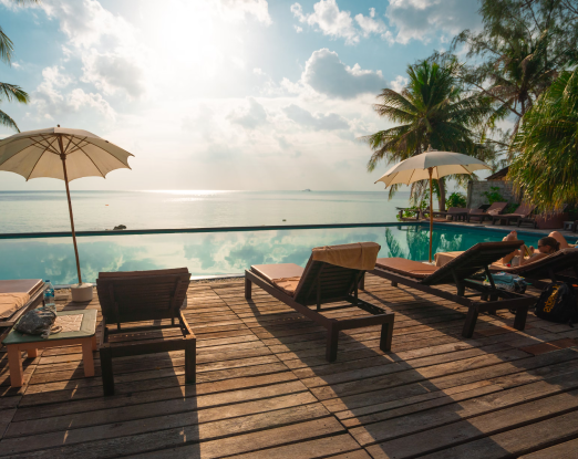 View of a wooden deck with sun swept lounge chairs with a breathtaking view