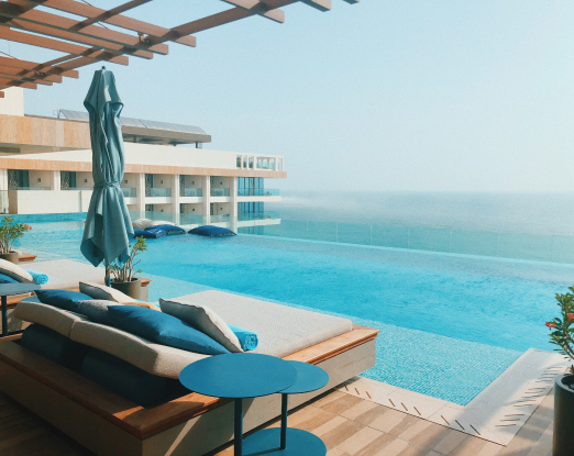 A poolside patio deck with clear blue water and a beautiful view