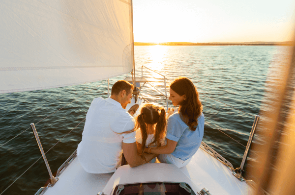 Two adults and a child sitting in a boat at sea