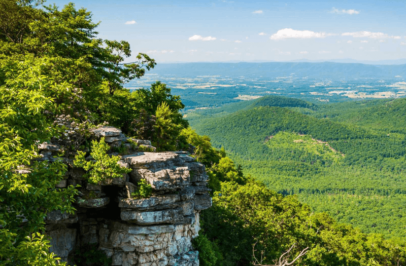 Crag with forested mountains in the background