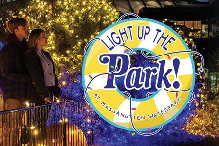 Man and woman looking at illuminated Light Up The Park sign